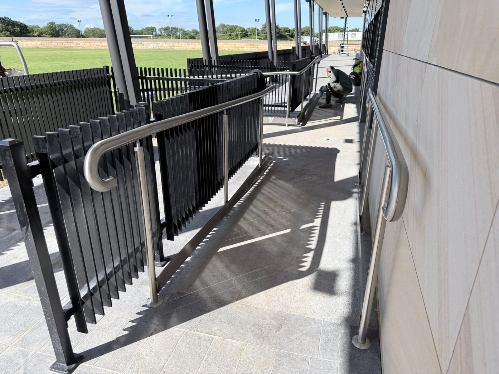 Stainless steel handrail on a powder-coated ramp balustrade