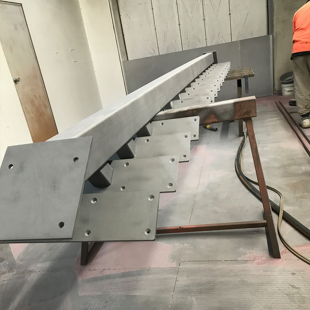 Custom steel staircase stringer with welded tread brackets fabricated in the Metalex workshop